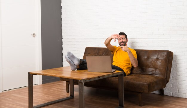 Homme avec son ordinateur portable dans une pièce en se concentrant sur le visage. Symbole d&#39;encadrement