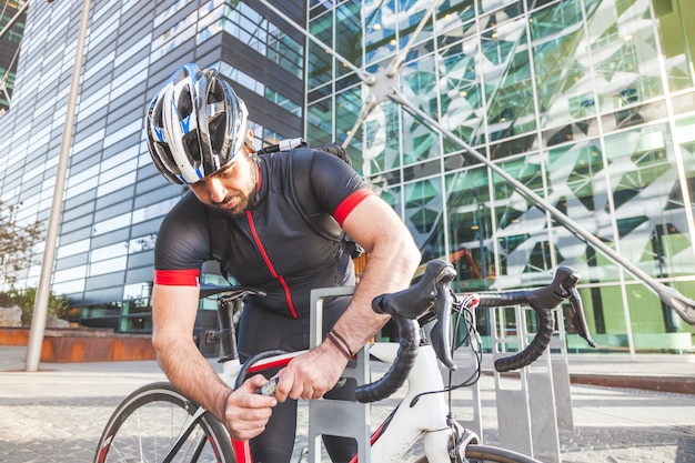 Homme avec son vélo en ville