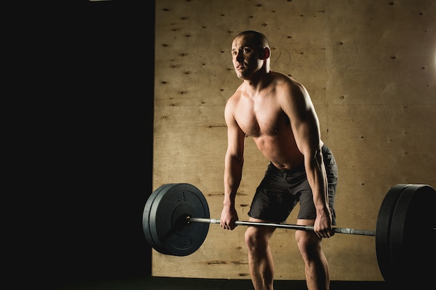 Homme soulevant des poids. séance d'entraînement homme musclé dans la salle de gym faire des exercices avec haltères