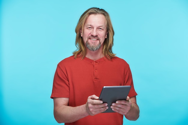 Homme souriant à l&#39;aide de tablet pc