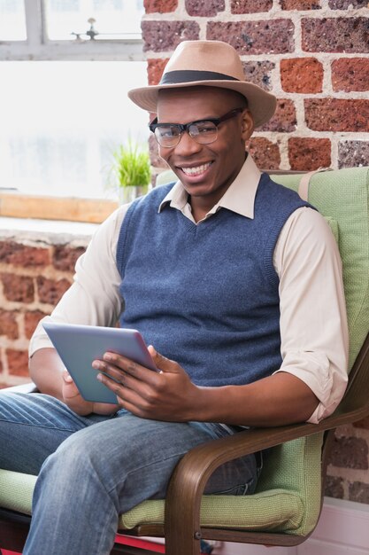 Homme souriant à l&#39;aide de tablette numérique