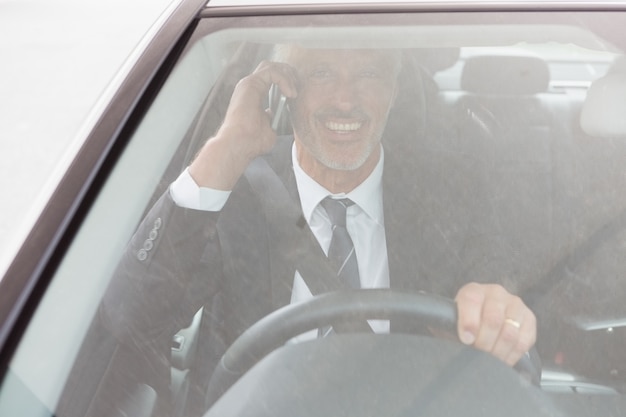 Homme souriant assis au volant