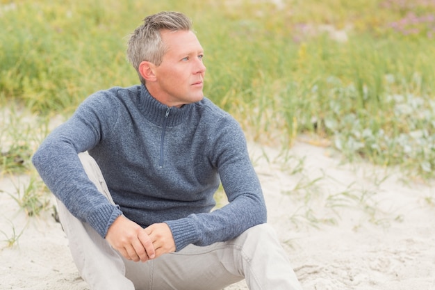 Photo homme souriant, assis sur le sable