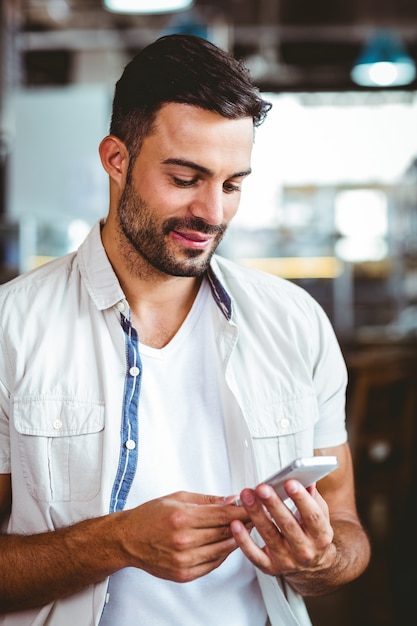 Homme souriant au téléphone en prenant un café