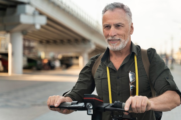 Homme souriant de coup moyen avec scooter