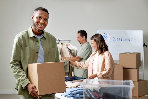 Photo homme souriant de coup moyen tenant une boîte