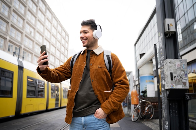 Homme souriant de coup moyen tenant le téléphone