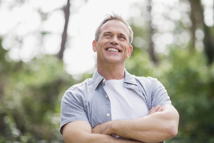 Photo homme souriant croisant ses bras à l'extérieur