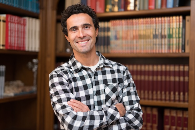 Homme souriant dans sa bibliothèque