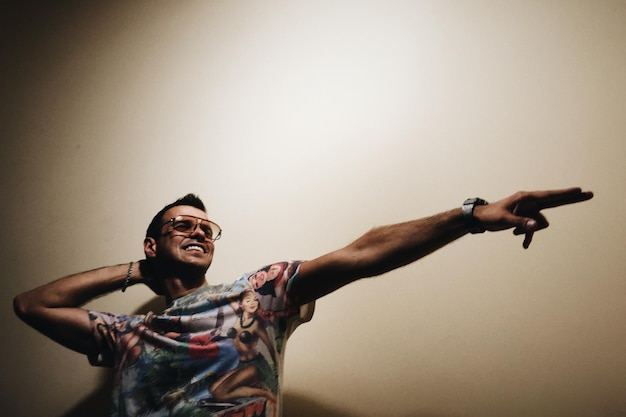 Photo un homme souriant dansant contre le mur.