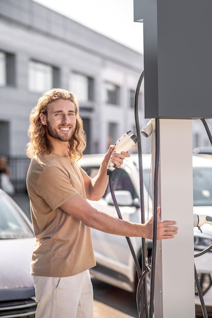 Homme souriant, debout à la station-service