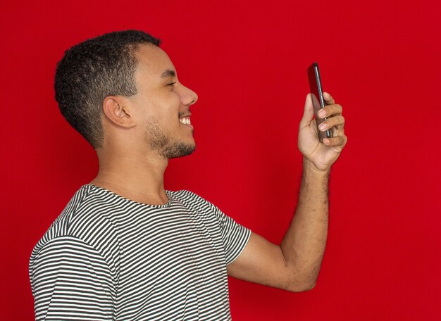 Homme souriant devant un téléphone portable isolé