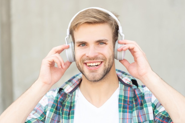 Homme souriant écoutant de la musique en plein air homme écoutant de la musique en dehors homme écoutant de la musique