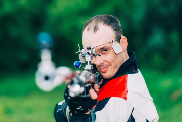 Homme souriant sur l'entraînement de carabine gratuit