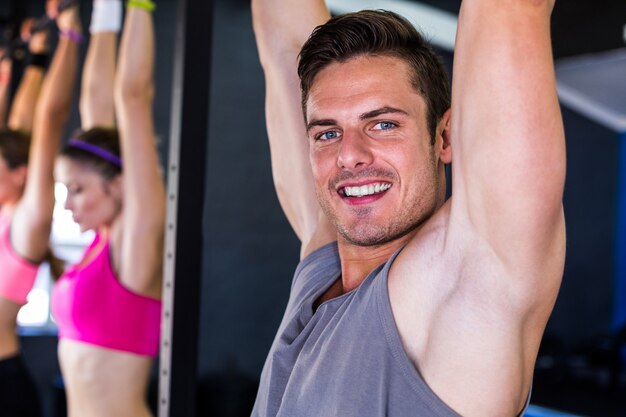 homme souriant, faire des tractions dans la salle de gym