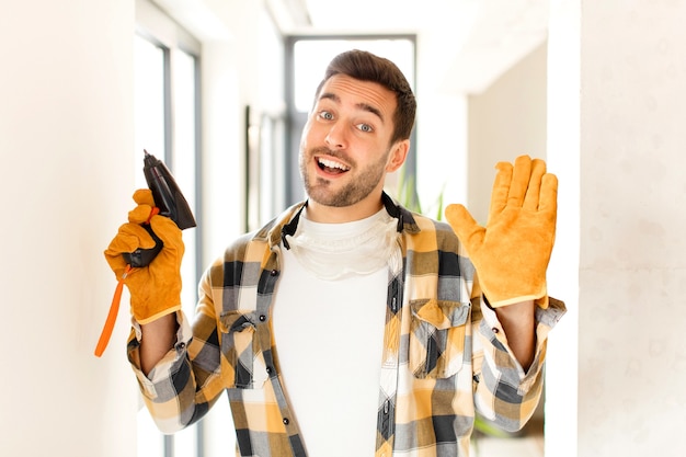 Homme souriant joyeusement et gaiement, agitant la main et vous saluant, ou disant au revoir