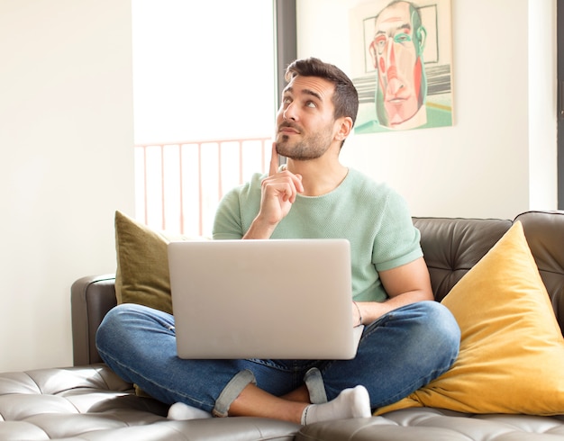 Homme souriant joyeusement et rêvassant ou doutant, regardant sur le côté