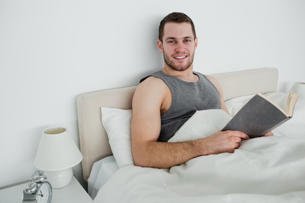 Homme souriant, lisant un roman
