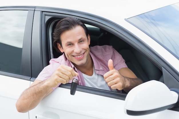 Homme souriant et montrant la clé