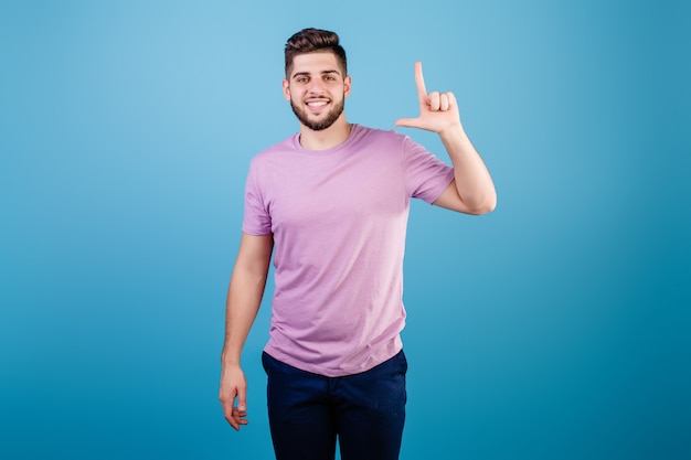 Homme souriant montrant deux doigts isolés sur bleu