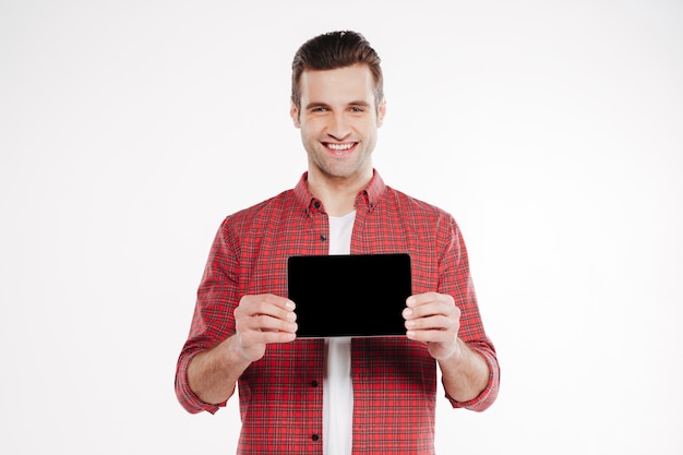 Homme souriant montrant l'écran d'ordinateur tablette vierge