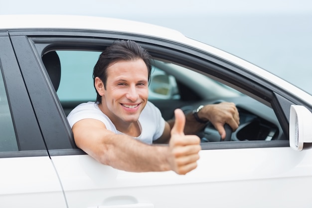 Homme souriant et montrant les pouces vers le haut