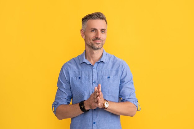 Homme souriant avec montre-bracelet sur accessoire de mode fond jaune