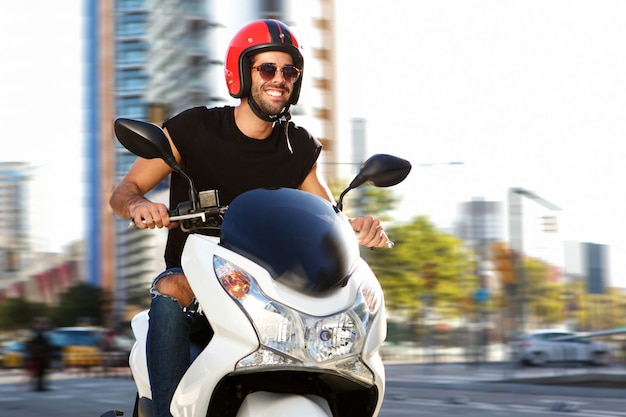 Homme souriant en moto dans la rue
