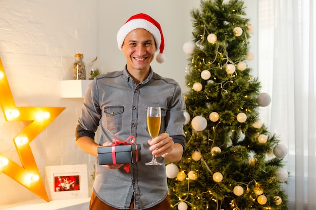 Homme souriant ouvrant des cadeaux de Noël à la maison