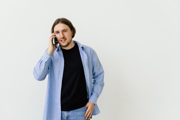 Homme souriant parlant sur un téléphone mobile isolé sur fond blanc