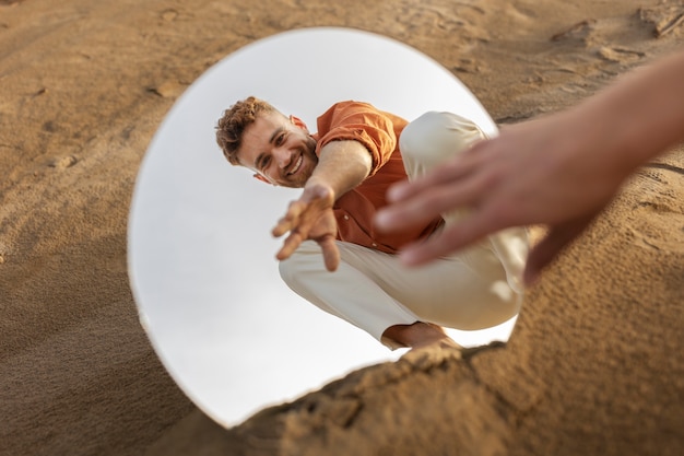 Photo homme souriant plein coup posant dans le miroir