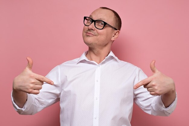 Homme souriant et pointant vers lui-même avec l'index étant sûr de lui