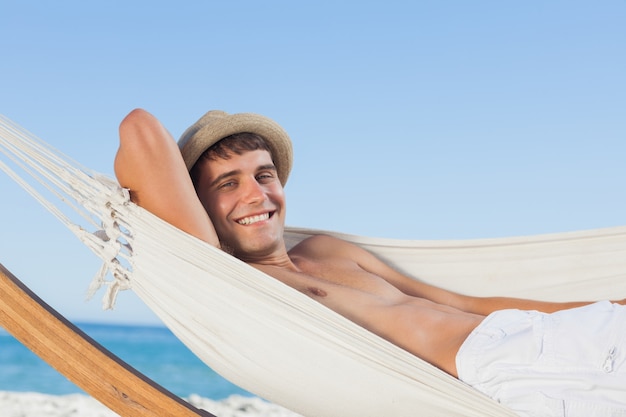 Homme souriant portant chapeau de paille à la recherche