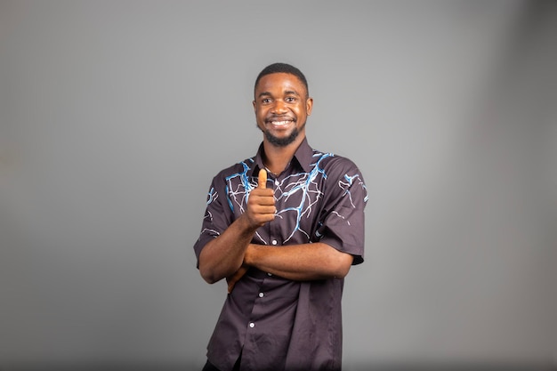 Photo un homme souriant posant avec les bras croisés sur un fond blanc et le pouce levé