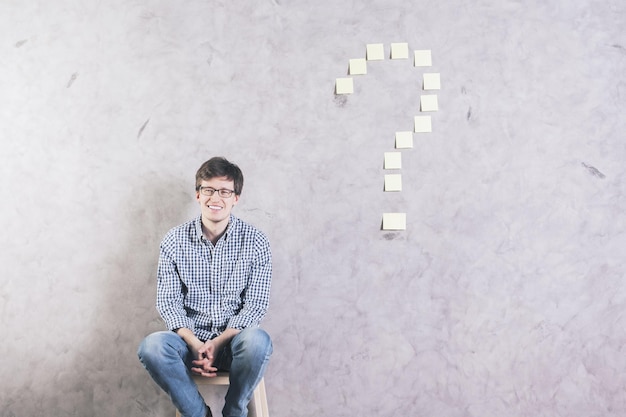 Homme souriant près du point d'interrogation