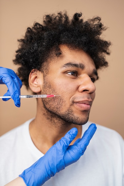 Photo homme souriant recevant une injection d'acide hyaluronique