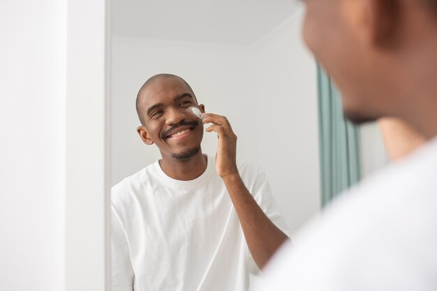 Homme souriant regardant dans le miroir