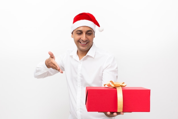 Homme souriant à Santa Hat montrant la grande boîte-cadeau