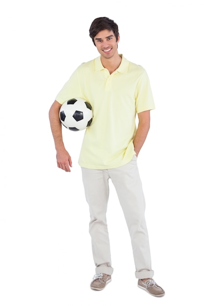 Homme souriant tenant un ballon de soccer