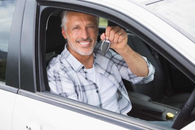 Homme souriant et tenant clé