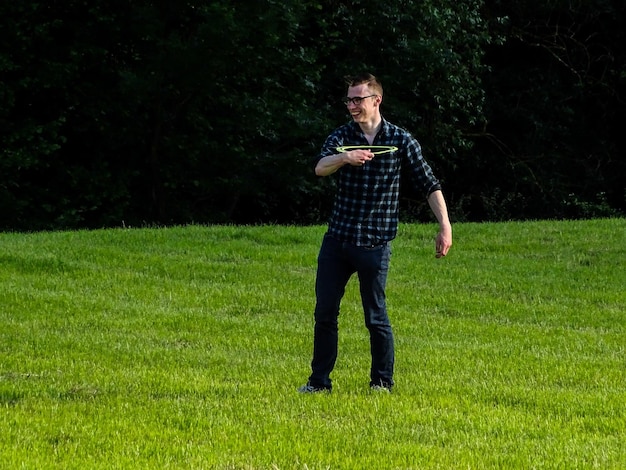 Un homme souriant tenant un disque en plastique alors qu'il se tient sur l'herbe