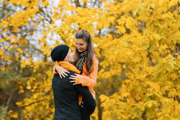 un homme souriant tient une femme dans ses bras