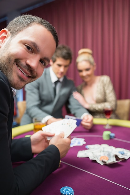 Homme souriant tout en étant assis à la table de poker