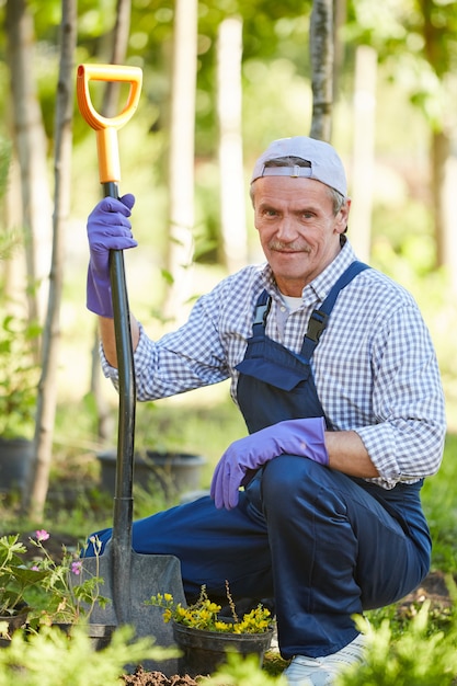 Homme souriant travaillant dans le jardin