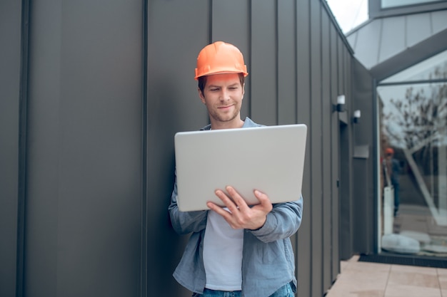 Homme souriant travaillant sur ordinateur portable à l'extérieur