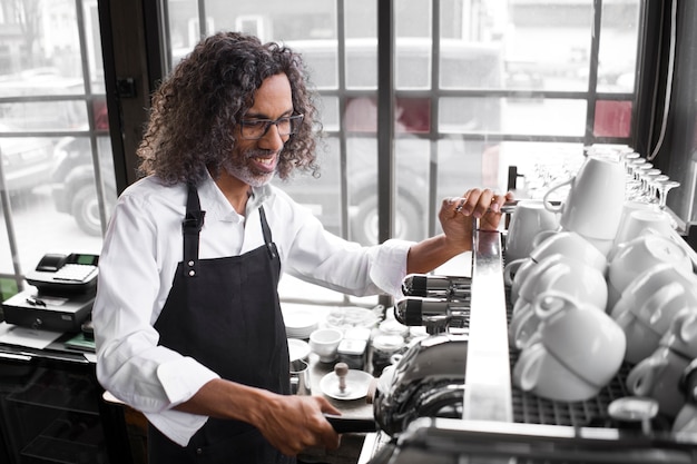 Homme souriant vue de côté avec machine à café