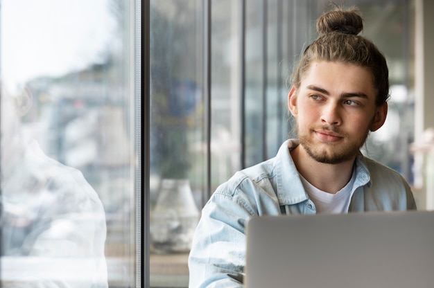 Photo homme souriant vue de face avec chignon désordonné