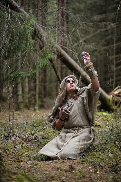 Un Homme En Soutane Passe Un Rituel Dans Une Forêt Sombre Avec Une Boule De Cristal Et Un Livre