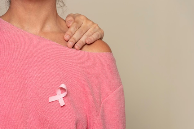 Homme soutenant une femme atteinte d'un cancer du sein et d'un ruban rose pour la sensibilisation