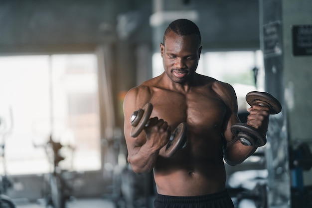 Homme de sport africain muscle fort travaillant sur l'exercice en poids avec haltère à la salle de fitness à la salle de gym Body building sport homme fitness concept